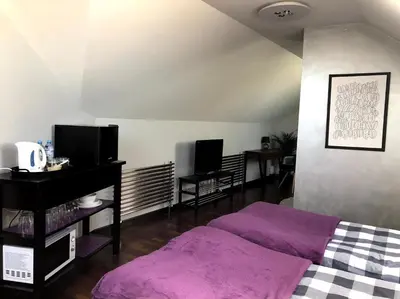 a bedroom with a purple bed and two monitors at Arkada Wadowice in Wadowice