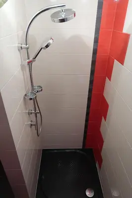a shower with a black floor in a bathroom at Arkada Wadowice in Wadowice