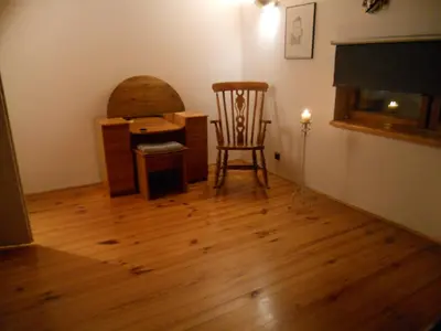 a room with a chair and a table and a desk at Apartament na Fatimskiej in Kraków