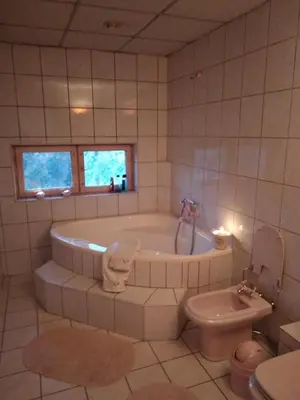 a white bathroom with a tub and a toilet at Apartament na Fatimskiej in Kraków