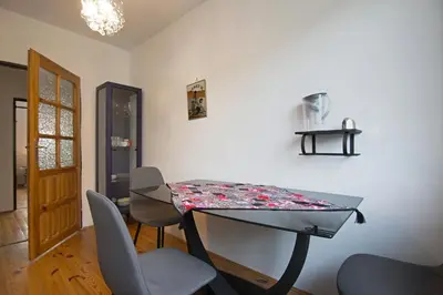 a dining room table with chairs and a tablecloth on it at Apartament na Fatimskiej in Kraków