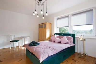 a bedroom with a large bed with pink pillows at Apartament na Fatimskiej in Kraków