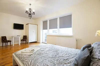 a large bedroom with a bed and a window at Apartament na Fatimskiej in Kraków