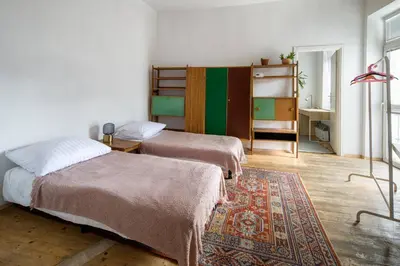 a bedroom with two beds and a rug at Tenement Apartment 90m2 City Center in Kraków