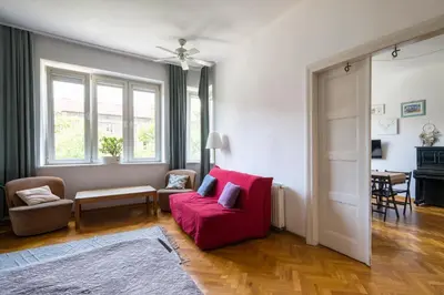 a living room with a red chair and a red couch at Tenement Apartment 90m2 City Center in Kraków