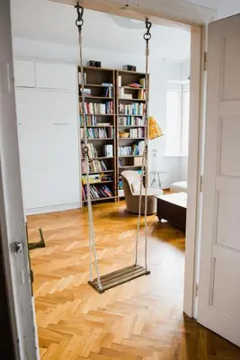 a swing in a living room with a book shelf at Tenement Apartment 90m2 City Center in Kraków