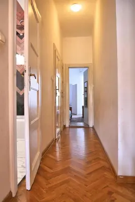 an empty hallway with a hard wood floor and an open door at Tenement Apartment 90m2 City Center in Kraków