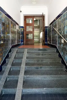 a staircase in a building with tiled floors and a door at Tenement Apartment 90m2 City Center in Kraków