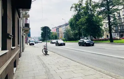 a bike parked on a sidewalk next to a street at Tenement Apartment 90m2 City Center in Kraków