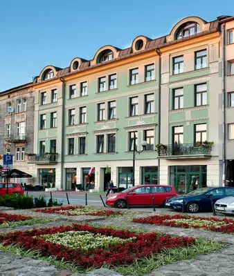 a large building with cars parked in front of it at Plaza Boutique Hotel in Kraków