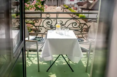 a table with a white table cloth on a balcony at Plaza Boutique Hotel in Kraków
