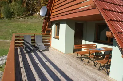 a view of a yard with a house and a fence at Domki Beskid in Rzyki