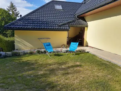 two blue chairs sitting in the yard of a house at Michałowice Noclegi u Anety in Michałowice