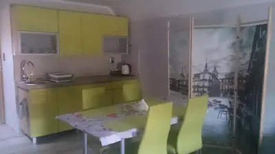 a kitchen with yellow and green cabinets and a table at Michałowice Noclegi u Anety in Michałowice