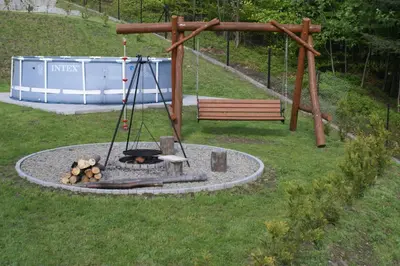 a wooden table with four chairs around it at Domki Beskid in Rzyki