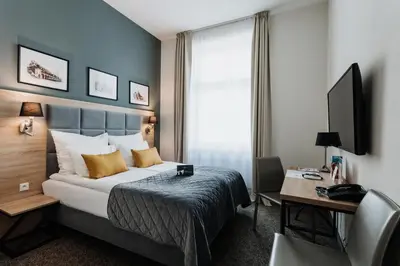 a hotel room with a bed and a desk with a computer at Hotel 32 Kraków Old Town in Kraków