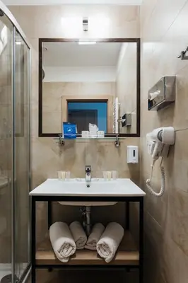 a bathroom with a sink and a mirror at Hotel 32 Kraków Old Town in Kraków