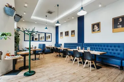 a restaurant with blue walls and tables and chairs at Hotel 32 Kraków Old Town in Kraków