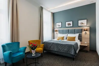 a hotel room with a bed and a chair at Hotel 32 Kraków Old Town in Kraków