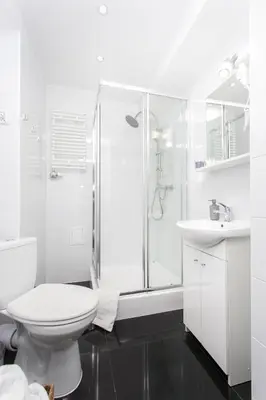 a white bathroom with a shower and a toilet at Krakow B&B - Old Town in Kraków
