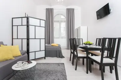a living room with a couch and a table and chairs at Krakow B&B - Old Town in Kraków