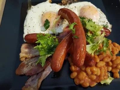 a plate of breakfast food with sausage beans and eggs at Krakow B&B - Old Town in Kraków