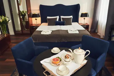 a hotel room with a bed with a tray of food on a table at Shalom Kazimierz in Kraków