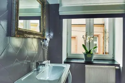 a bathroom with a sink and a mirror and a window at Shalom Kazimierz in Kraków