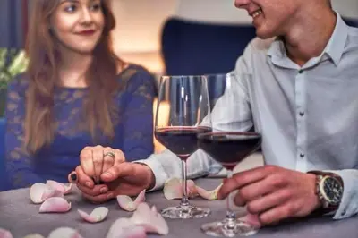 a man and woman sitting at a table with wine glasses at Shalom Kazimierz in Kraków