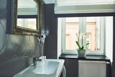 a bathroom with a sink and a mirror and a window at Shalom Kazimierz in Kraków