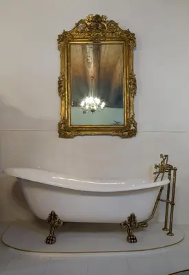 a bath tub in a bathroom with a mirror at Orlowska Townhouse Apartments in Kraków