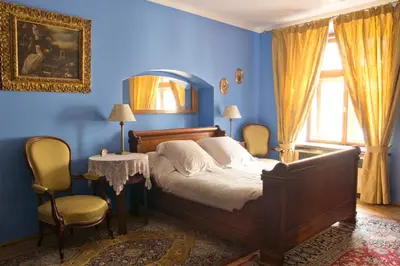 a blue bedroom with a bed and a table and chairs at Orlowska Townhouse Apartments in Kraków