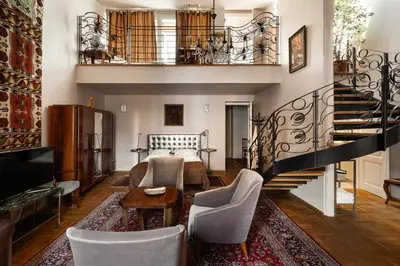 a living room with a staircase and a bed at Orlowska Townhouse Apartments in Kraków