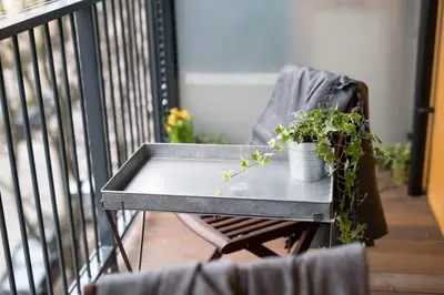 a table with a potted plant on a balcony at Krakow Central Apartment Free Parking in Kraków