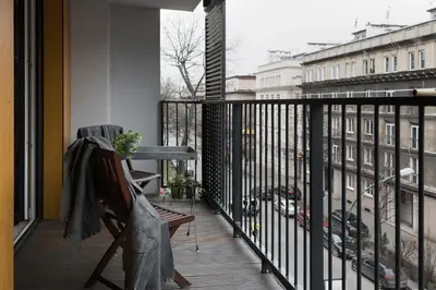 a balcony with a chair and a view of a city at Krakow Central Apartment Free Parking in Kraków