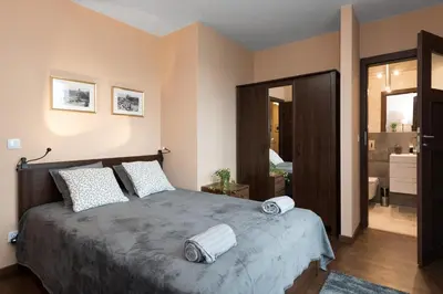 a bedroom with a large bed with two towels on it at Krakow Central Apartment Free Parking in Kraków