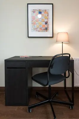 a black desk with a chair and a lamp at Krakow Central Apartment Free Parking in Kraków