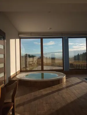 a room with a large window with a hot tub at Hotel Góralski Raj in Nowy Targ