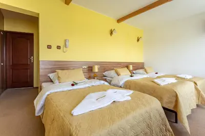 a hotel room with two beds with towels on them at Hotel Góralski Raj in Nowy Targ