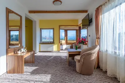 a living room with a chair and a table at Hotel Góralski Raj in Nowy Targ