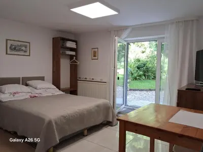 a bedroom with a bed and a table and a sliding glass door at Studio in Kraków