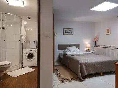 a bedroom with a bed and a washing machine at Studio in Kraków