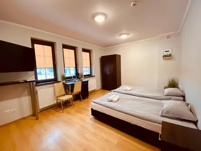 a bedroom with two beds and a desk in it at Nasz Młyn in Sufczyn