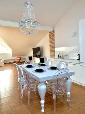 a dining room with a white table and chairs at Divon Luxury Apartments by Wawel Castle in Kraków