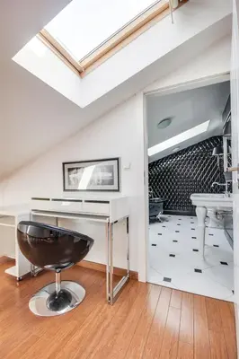 a bathroom with a sink and a stool at Divon Luxury Apartments by Wawel Castle in Kraków