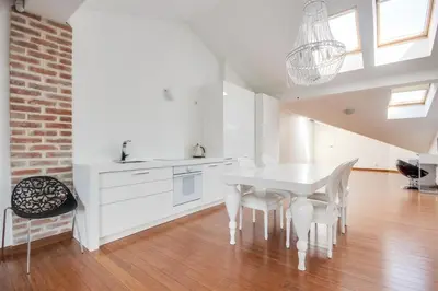 a white kitchen with a white table and chairs at Divon Luxury Apartments by Wawel Castle in Kraków