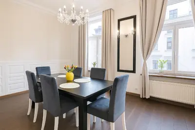 a dining room with a black table and chairs at Divon Luxury Apartments by Wawel Castle in Kraków