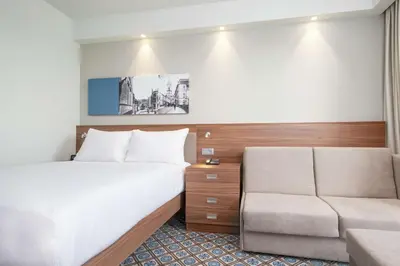 a hotel room with a bed and a couch at Hampton by Hilton Oswiecim in Oświęcim
