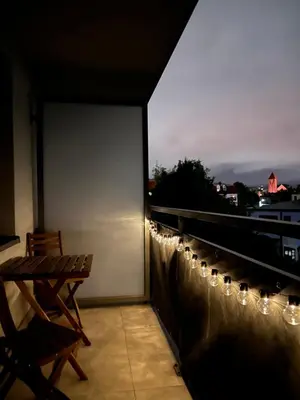 a balcony with a bench and lights on a roof at Apartamenty Lea in Kraków
