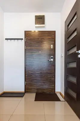 a wooden door in a room with a tile floor at Apartamenty Lea in Kraków